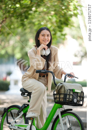 A woman is sitting on a bicycle with a basket on the back A woman is sitting on a bicycle with a basket on the back 119871757