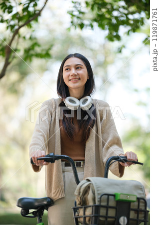A woman is riding a bicycle with a basket on the back 119871761