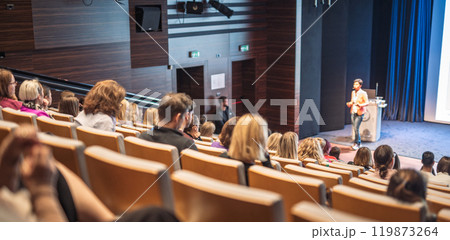 Speaker giving a talk in conference hall at business event. Rear view of unrecognizable people in audience at the conference hall. Business and entrepreneurship concept 119873264