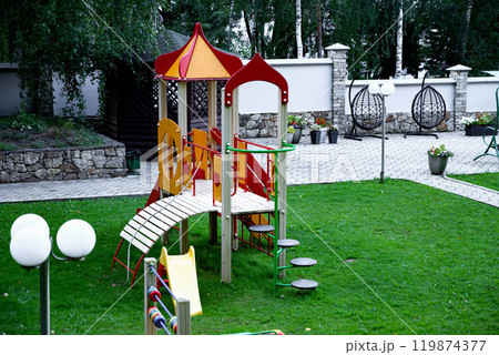 Colorful playground with slide and climbing structure in park. Colorful playground with slide and climbing structure in park. 119874377