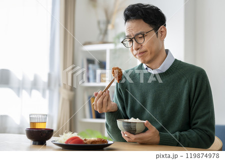 唐揚げを見つめて考え込む食事中のアラフォーの男性 唐揚げを見つめて考え込む食事中のアラフォーの男性 119874978