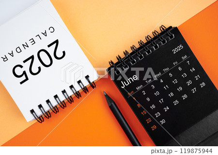June 2025 desk calendar black and white color with pencil on orange background. June 2025 desk calendar black and white color with pencil on orange background. 119875944