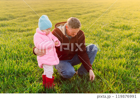 Grandfather and granddaughter walking in field with warm sunlight Grandfather and granddaughter walking in field with warm sunlight 119876991