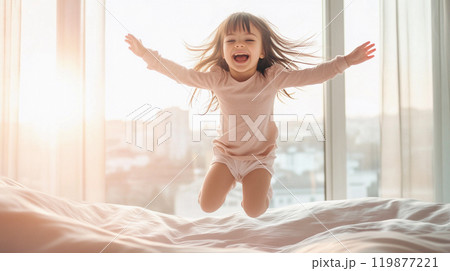 Little girl jumping on bed after waking up in the morning. Child in white bedroom with big window with city view. Kids play at home. Funny baby girl. This is AI-generated item 119877221