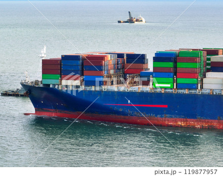 Aerial view of container cargo ship at sea. International shipping and logistics. Maritime freight transportation. Global trade and export import industry. Commercial vessel carrying containers. 119877957