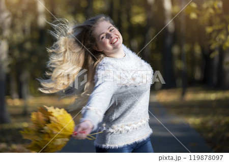 Cheerful woman with fluttering hair in the autumn park. Cheerful woman with fluttering hair in the autumn park. 119878097