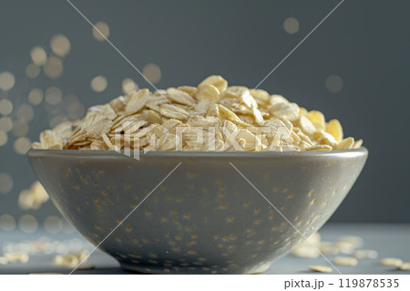 Oat flakes in a bowl on a gray background with bokeh 119878535