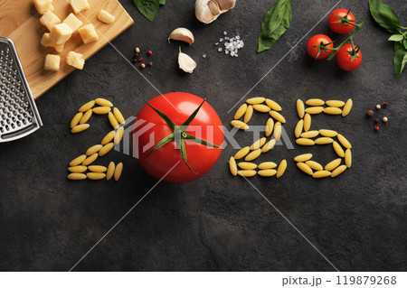 Numbers 2025 made of pasta and tomato on a dark stone background. A culinary idea for the new year. 119879268