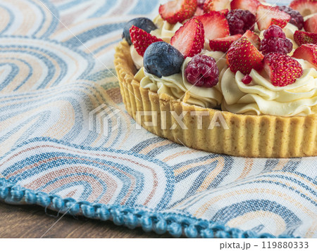 A beautifully arranged fruit tart is garnished with strawberries and blueberries 119880333