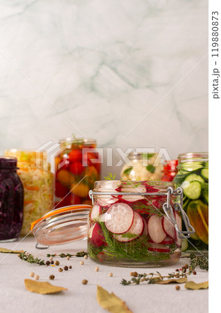 Fresh radishes with fermenting in a jar with spices, creating a healthy probiotic-rich food, fresh fermenting vegetables like cabbage, tomatoes, cucumbers, cauliflower Fresh radishes with fermenting in a jar with spices, creating a healthy probiotic-rich food, fresh fermenting vegetables like cabbage, tomatoes, cucumbers, cauliflower 119880873