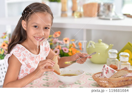 Little girl having breakfast in the kitchen at home 119881084