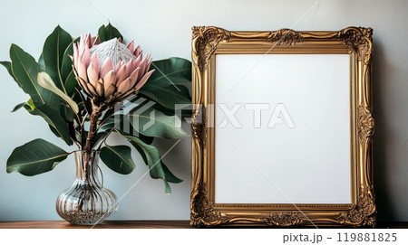 A gold vintage frame mockup is leaning against the wall with a pink king protea flower in a vase. 119881825
