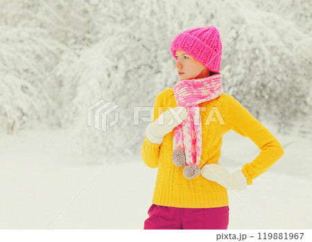 winter young woman wearing colorful knitted hat, sweater, scarf over snowy forest or park background winter young woman wearing colorful knitted hat, sweater, scarf over snowy forest or park background 119881967