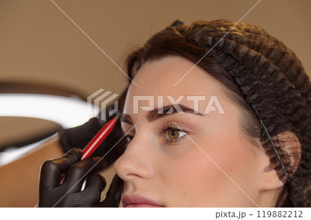 The cosmetologist creates the perfect eyebrow contour for tattooing 119882212