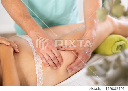 massage therapist doing a leg massage massage therapist doing a leg massage 119882301
