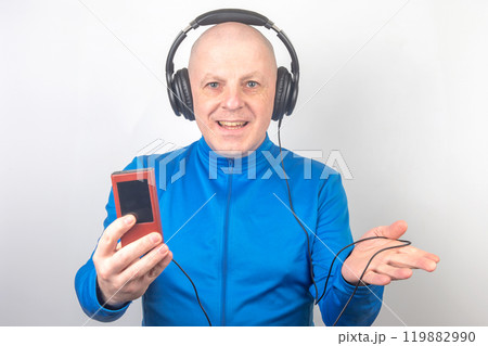 man with headphones and digital portable player in hand relaxes while listening to his music 119882990
