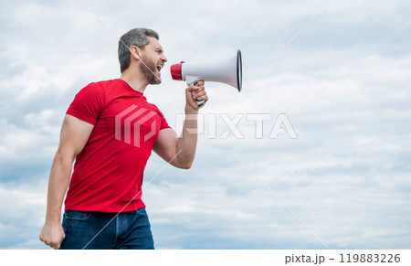 man in red shirt shouting in loudspeaker on sky background man in red shirt shouting in loudspeaker on sky background 119883226