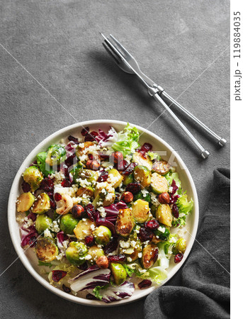 Salad of roasted brussels sprouts with lettuce, quinoa, nuts and cranberries in a plate 119884035