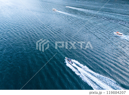 High-Speed Boats Cutting Through the Calm Blue Waters on a Sunny Day High-Speed Boats Cutting Through the Calm Blue Waters on a Sunny Day 119884207