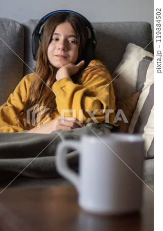 Cute girl listening to music with a sad and nostalgic look. Vertical shot 119884502