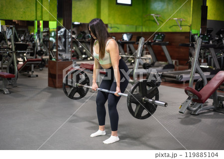 Young caucasian woman doing deadlift in the gym. Young caucasian woman doing deadlift in the gym. 119885104