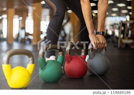 Athletic bodybuilding sport woman squat with kettlebell fitness training at gym 119888186