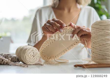 Close-up of a young girl's hands in a white dress. The woman crochets the bottom 119888249