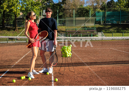 Smiling couple tennis players hugging posing together at outdoor summer sunny court 119888275