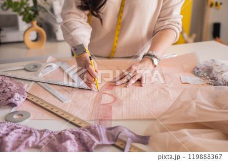 A woman seamstress designs and draws a pattern for underwear on graph paper. Various patterns A woman seamstress designs and draws a pattern for underwear on graph paper. Various patterns 119888367