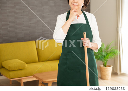 家のリビングで笑う緑のエプロンをしたシニア女性の主婦・家政婦 119888988
