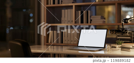 A laptop, a microphone, and headphone on a table in a modern office at night. A laptop, a microphone, and headphone on a table in a modern office at night. 119889182