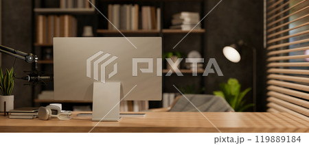A back view of a computer on a wooden desk in a contemporary podcast radio office at night. A back view of a computer on a wooden desk in a contemporary podcast radio office at night. 119889184