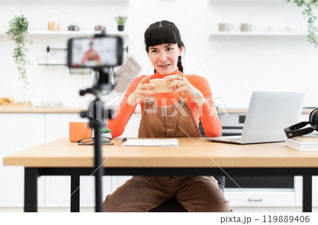 Caucasian female blogger unpacking items in modern home studio Caucasian female blogger unpacking items in modern home studio 119889406