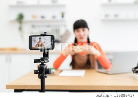 Caucasian woman filming unboxing video for her online lifestyle blog Caucasian woman filming unboxing video for her online lifestyle blog 119889417