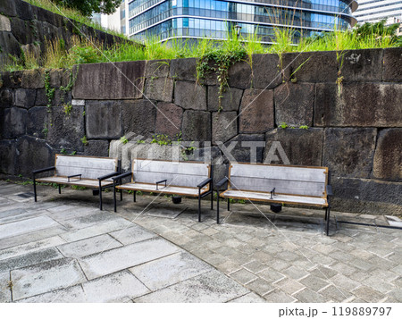 仕切りの付いた木製ベンチと石垣 119889797