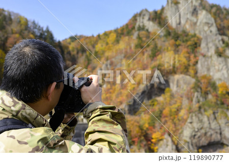 秋の【北海道 豊平峡】で写真を撮る男性 119890777