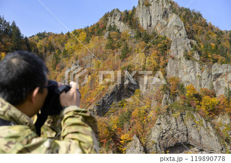 秋の【北海道 豊平峡】で写真を撮る男性 119890778