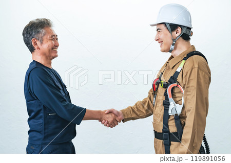 握手する職人と作業員 握手する職人と作業員 119891056