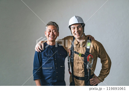 笑顔で肩を組む職人と作業員 笑顔で肩を組む職人と作業員 119891061