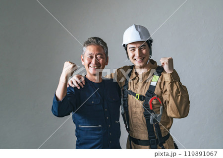 笑顔でガッツポーズする職人と作業員 笑顔でガッツポーズする職人と作業員 119891067