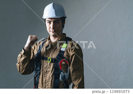 ヘルメットをかぶってガッツポーズする男性作業員 119891073