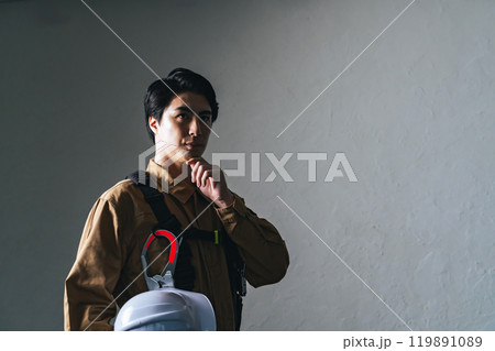 作業服を着て考える男性作業員 作業服を着て考える男性作業員 119891089