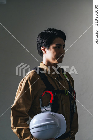 作業服を着てヘルメットを持つ男性作業員 作業服を着てヘルメットを持つ男性作業員 119891090