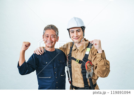 笑顔でガッツポーズする職人と作業員 119891094