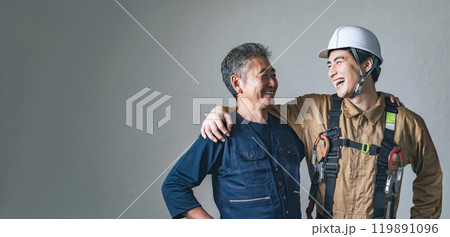 笑顔で肩を組む職人と作業員 笑顔で肩を組む職人と作業員 119891096