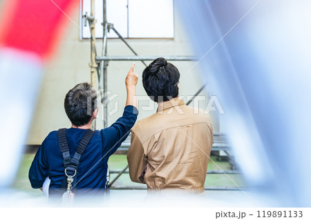 建設現場で確認する作業員グループの後ろ姿 建設現場で確認する作業員グループの後ろ姿 119891133
