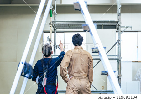 建設現場で確認する作業員グループの後ろ姿 建設現場で確認する作業員グループの後ろ姿 119891134