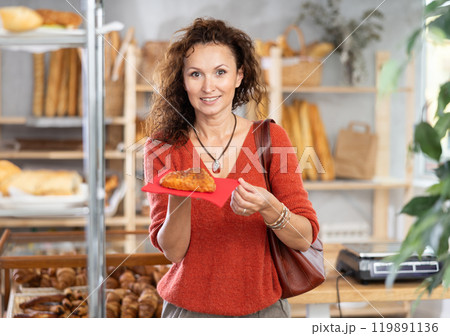 Portrait of happy female customer holding baked pie in her hands 119891136