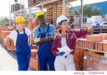 Three workers are discussing work issues at the warehouse Three workers are discussing work issues at the warehouse 119891449
