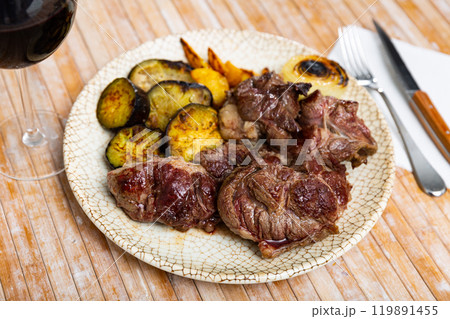Serving of grilled beef with potatoes and eggplant on side 119891455